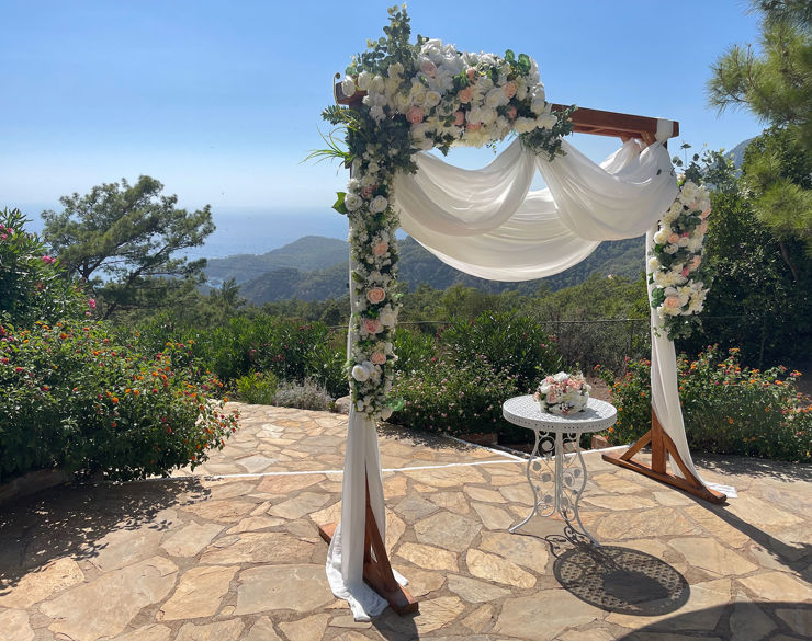 Wedding setup with a small table with flowers on it and a garden view
